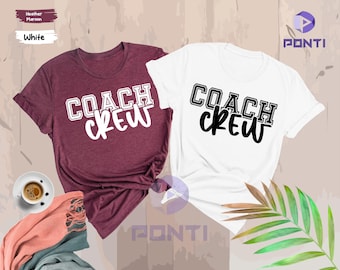 May include: Two t-shirts with the text "Coach Crew" printed on them. One shirt is white and the other is heather maroon.