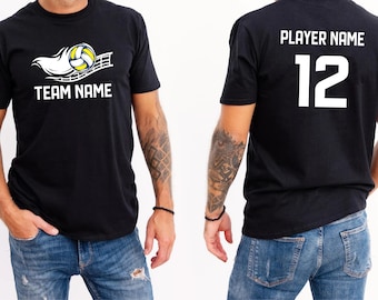 May include: Black t-shirt featuring a volleyball graphic with a net and a stylized white trail. The shirt has the text "TEAM NAME" on the front and "PLAYER NAME" and the number "12" on the back. The person is wearing blue jeans.