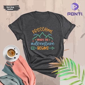 May include: Dark gray heather t-shirt with the text "Preschool Where the Adventure Begins" in colorful letters with a mountain range graphic.
