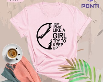 May include: Pink t-shirt with a black baseball graphic and the text "I know I play like a girl try to keep up".