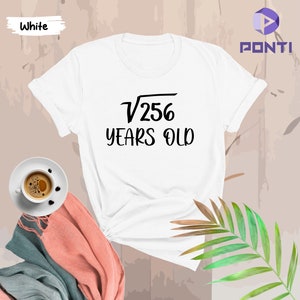 May include: White t-shirt with black text that reads "√256 YEARS OLD".