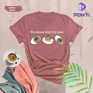 May include: Heather mauve t-shirt with the text "You know why I'm here." and a graphic of three deviled eggs.