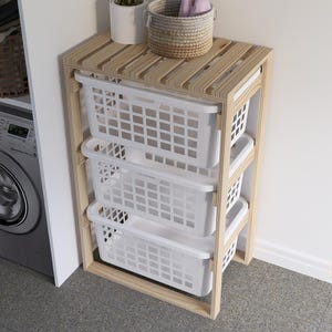 May include: A wooden laundry storage unit with three white plastic baskets. The unit has a slatted top shelf and is made of natural wood.