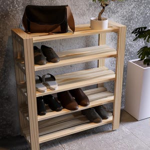 May include: A wooden shoe rack with five shelves. The rack is made of natural wood and has a rustic look. It is filled with shoes, including sandals, sneakers, and dress shoes.