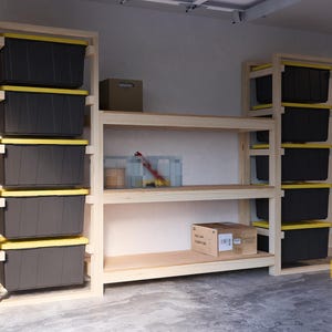 May include: A wooden shelving unit with multiple shelves and storage bins. The shelves are made of natural wood and the bins are black with yellow lids. The unit is assembled and ready to use.