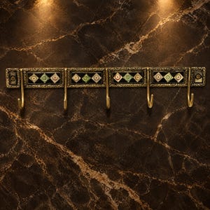 May include: A horizontal wall-mounted coat rack featuring five brass-toned metal hooks. The rectangular frame has an antique gold finish with ornate detailing and inlaid panels containing repeating diamond-shaped patterns in black, white, and green.
