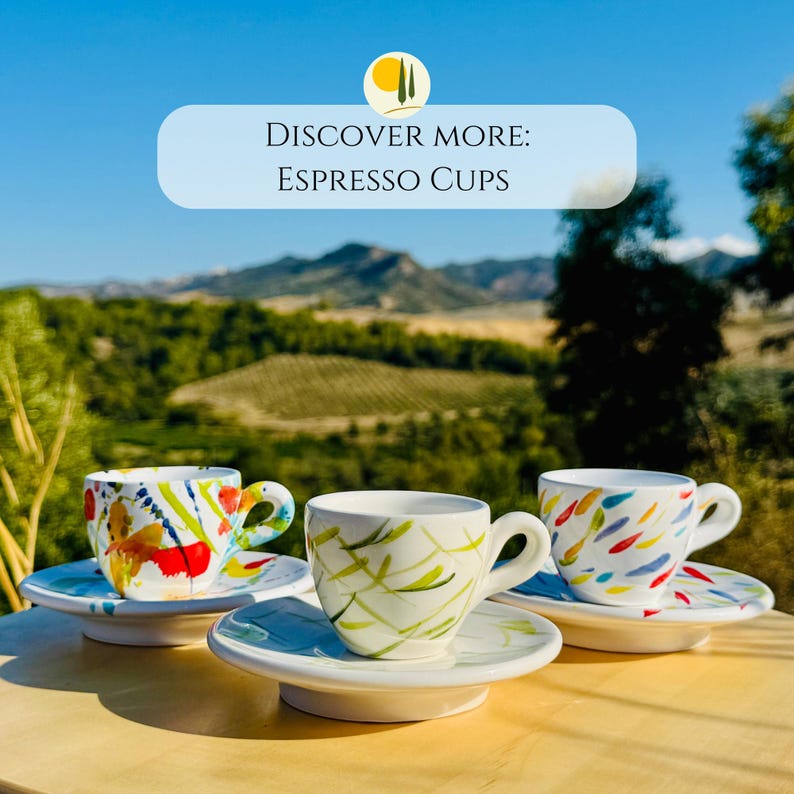 May include: Three white ceramic espresso cups with matching saucers, each featuring distinct hand-painted colourful patterns including abstract red, yellow, and blue brushstrokes. The text DISCOVER MORE: ESPRESSO CUPS is visible at the top of the image.