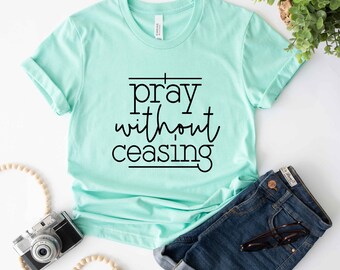 Peut inclure: Un t-shirt bleu clair avec le texte "prier sans cesse" en lettres noires.