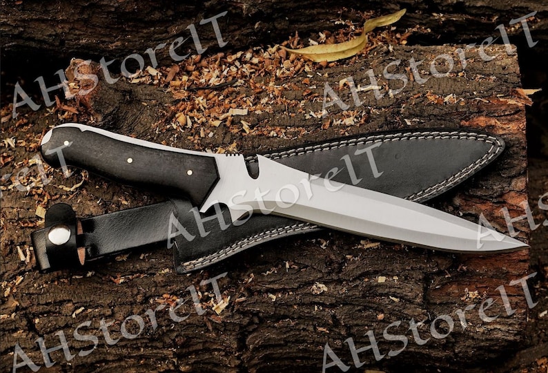 May include: A black-handled knife with a silver blade and a leather sheath. The knife has a unique design with a serrated edge and a pointed tip.