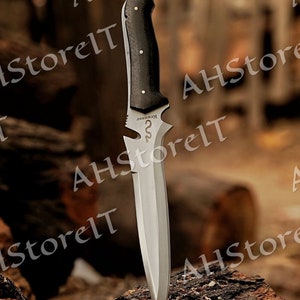 May include: A silver knife with a black wooden handle. The knife has a serrated edge and a pointed tip. The handle has a small metal plate with the word "KRHISSER" engraved on it.