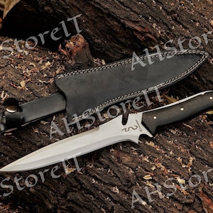 May include: A black leather sheath with a silver knife with a black wooden handle. The knife has a curved blade and the text "REMARK" is engraved on the blade.