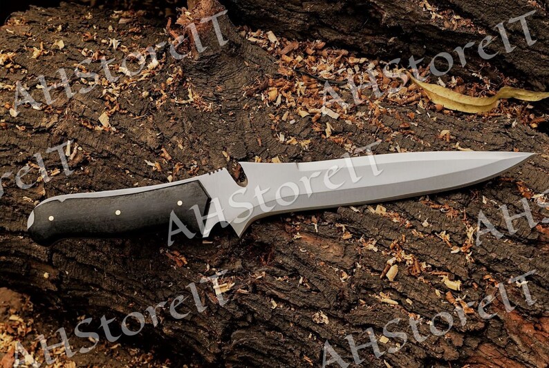 May include: A black-handled knife with a silver blade. The knife is lying on a brown, textured surface.