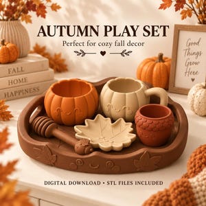 May include: An autumn play set featuring a brown tray with leaf and face motifs, an orange pumpkin bowl, a beige pumpkin mug, a small brown acorn cup, and a brown honey dipper, all with smiling faces, plus a beige leaf-shaped dish.