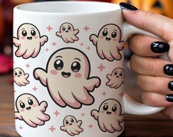 Puede incluir: Taza de cerámica blanca con un patrón repetido de fantasmas de dibujos animados lindos en varios tamaños, con acentos rosas y estrellas. La taza tiene un asa blanca. El fondo incluye calabazas y follaje de otoño.