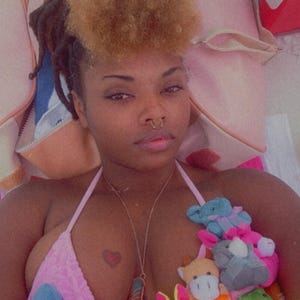May include: Pink bikini top adorned with plush toy embellishments. The top features a heart-shaped pendant and a small heart tattoo. The plush toys include a blue star, a yellow bunny, and other colorful creatures.
