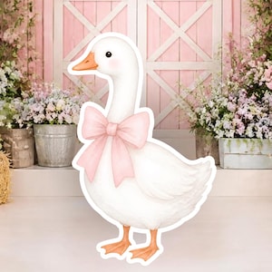 May include: A white goose illustration featuring a large, soft pink bow around its neck. The goose has a bright orange beak and black eyes, presented as a cutout figure with a clean white border, standing against a backdrop of a pink barn.
