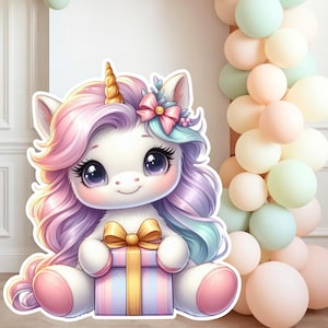 May include: A charming unicorn illustration with a white body, pink and purple mane, and a golden horn. The unicorn holds a gift box with a gold bow. Pastel balloons in pink, green, and peach are in the background. A cute design for a birthday party.