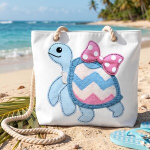 Può includere: Una borsa tote in tela bianca con una grande applicazione di una tartaruga azzurra con un guscio a motivi. Il guscio presenta strisce a chevron rosa e blu e un fiocco rosa a pois bianchi. La borsa include spessi manici in corda color crema.