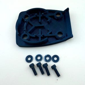 May include: A black plastic 3D printed part with four holes and a complex internal design. The part is accompanied by four black washers and four black screws.
