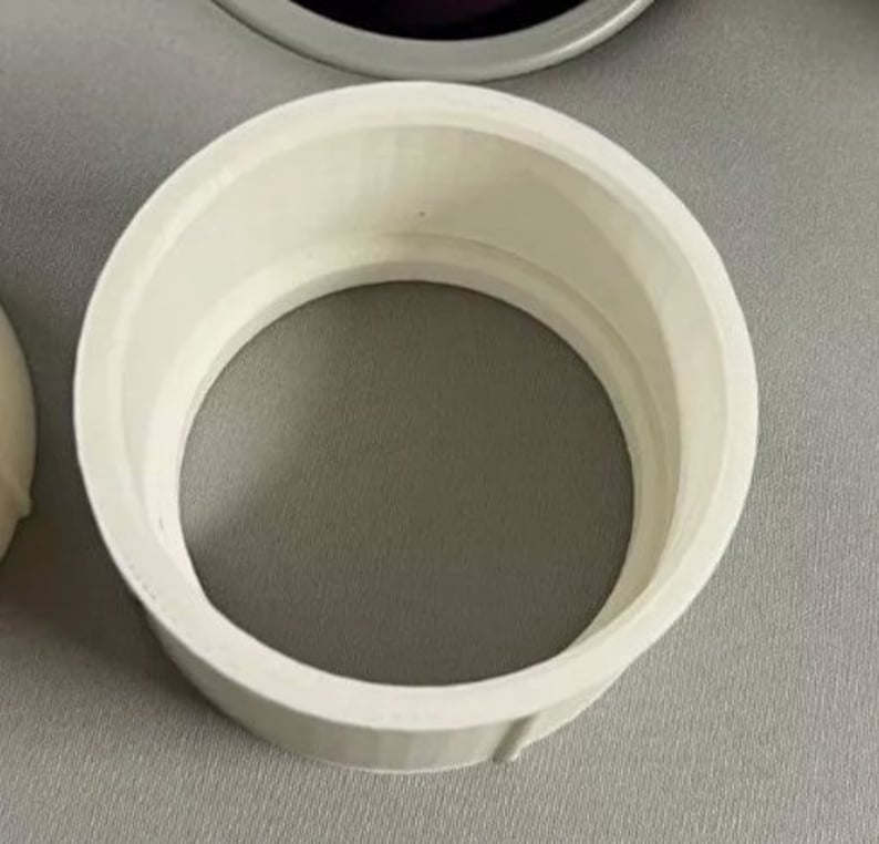 Puede incluir: Un objeto circular blanco con un borde ancho y un centro hueco. El objeto parece estar hecho de un material s&oacute;lido y tiene una superficie lisa y limpia. El dise&ntilde;o es simple y funcional.