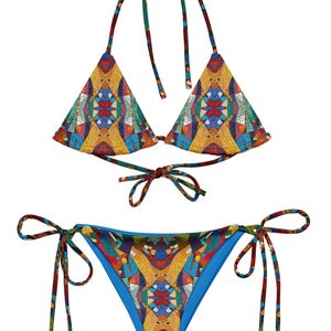 Może przedstawiać: Dwuczęściowy zestaw bikini z kolorowym geometrycznym wzorem. Góra to trójkąt z wiązaniami, a dół ma wiązania po bokach. Wzór zawiera odcienie żółtego, pomarańczowego, niebieskiego i czerwonego.
