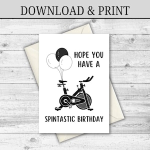 Può includere: Biglietto di compleanno bianco con un'illustrazione in bianco e nero di una cyclette e tre palloncini. Il biglietto recita "HOPE YOU HAVE A SPINTASTIC BIRTHDAY". Il biglietto è all'interno di una busta color crema.