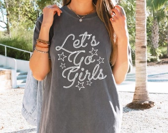 May include: A gray t-shirt with a white rope design that says "Let's Go Girls" with stars around the text.