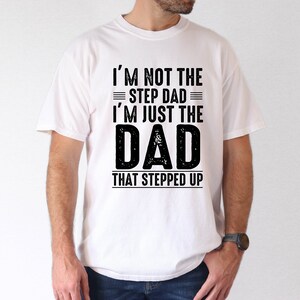 May include: White t-shirt with black text that reads "I'm not the step dad I'm just the DAD that stepped up".