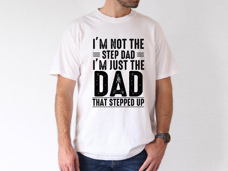 May include: White t-shirt with black text that reads "I'm not the step dad I'm just the DAD that stepped up".
