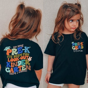 May include: Two children wearing black t-shirts with colourful text. The shirt on the left says "So long PRE-K It's been fun Look out KINDERGARTEN here I come!" The shirt on the right says "PRE-K GRAD Olivia".