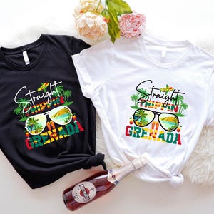 Może przedstawiać: Dwie koszulki, jedna czarna i jedna biała, z grafiką z napisem "Straight Trippin' in Grenada". Projekt zawiera okulary przeciwsłoneczne, palmy i kolory flagi Grenady. Butelka wina znajduje się na pierwszym planie.