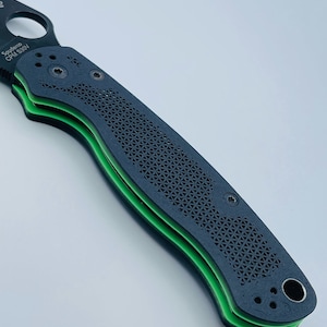 May include: A black pocket knife with a green handle and the text "Spyderco CPM S30V" on the blade.