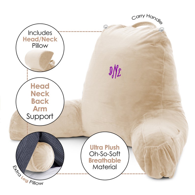May include: A beige plush reading pillow with a carry handle and a monogrammed "DNL". The pillow has a headrest, armrests, and a leg pillow. The pillow is described as "Ultra Plush Oh-So-Soft Breathable Material".