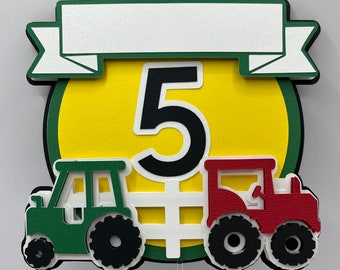 May include: Green and red toy tractors flanking a yellow circle with a black number 5 and a white banner above. The banner has a white background and a green border.