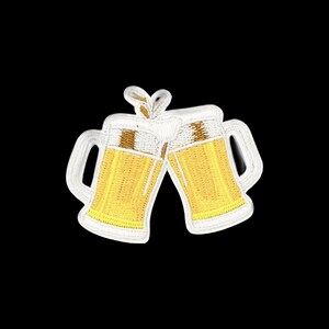 Può includere: Una toppa ricamata raffigurante due boccali di birra che si scontrano. I boccali sono gialli con schiuma bianca in cima e manici bianchi, raffigurati in posizione di brindisi con un piccolo schizzo di liquido visibile tra i due bicchieri.