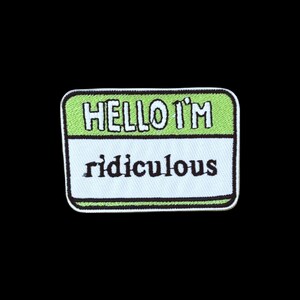 Peut inclure: Un écusson brodé rectangulaire présentant une section supérieure vert clair avec le texte blanc HELLO I'M et une section inférieure blanche avec le texte noir ridiculous. L'écusson a une bordure noire épaisse et des coins arrondis.