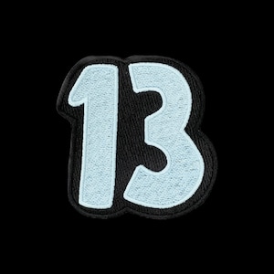 May include: A patch featuring the number 13 embroidered in light blue thread with a thick black border. The design has a rounded, block-style font shape with a black background fill that follows the contour of the digits, creating a bold contrast.
