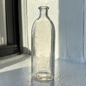 Antieke glazen babyfles: vintage kinderkamerdecoratie, fotorekwisieten