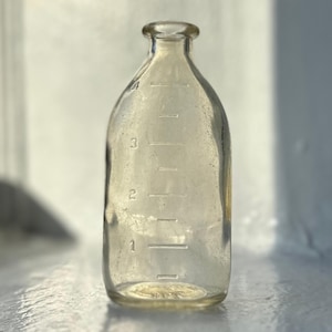 Antieke glazen babyfles: vintage kinderkamerdecoratie, fotorekwisieten
