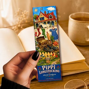 Op de afbeelding: Een rechthoekige boekenlegger met een kleurrijke illustratie van een huis, een waslijn en een schatkist. De boekenlegger toont de tekst "Pippi Longstocking" en de naam van de auteur. Op de achtergrond zijn een boek en een kopje koffie te zien.