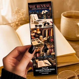 May include: A bookmark featuring scenes from "The Devil Wears Prada" with the title "The Runway". The bookmark showcases fashion, cityscapes, and a quote. The background includes an open book and a coffee mug.