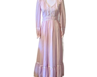 May include: A long, pink dress with white lace trim. The dress has a fitted bodice and a flowing skirt with multiple tiers. The dress has long sleeves with lace cuffs.