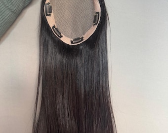 以下が含まれることがあります： メッシュベースとクリップが付いた黒髪のヘアトッパー。髪は長く、ストレートで、深い黒色です。ベースは明るいベージュ色です。