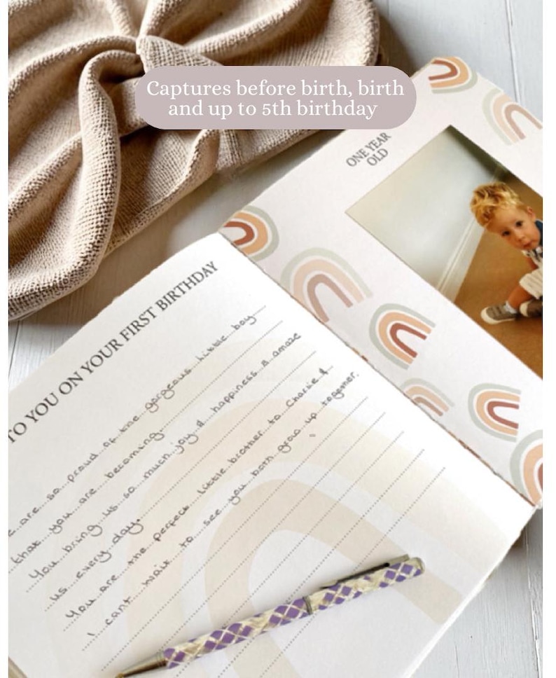 May include: A white journal with a rainbow design and the text "To You On Your First Birthday" and "One Year Old". The journal has a photo slot with a picture of a young boy.