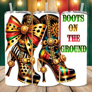 May include: A white tumbler with a colorful illustration of a high-heeled boot with a large bow. The text "BOOTS ON THE GROUND" is printed on the tumbler.