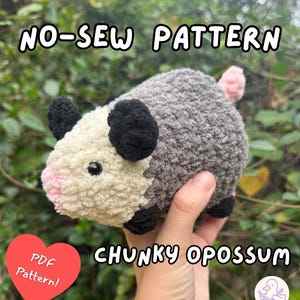 May include: A handmade, chunky opossum plushie with a gray body, cream-colored face, and pink nose and tail. The plushie has black ears and feet. Text on the image reads "NO-SEW PATTERN" and "CHUNKY OPOSSUM". A red heart with "PDF Pattern!" is also visible.