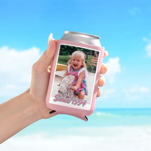 May include: Pink can cooler with a photo of a young girl on a swing set. The text "Since 1994" is printed on the cooler.
