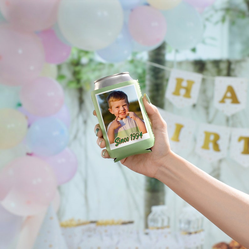 May include: Green can cooler with a photo of a young boy smiling and pointing to his teeth. The text "Since 1994" is printed on the cooler.