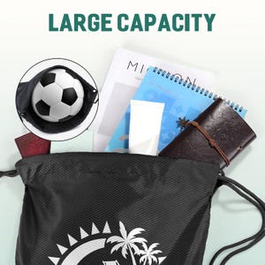 以下が含まれることがあります： 白いヤシの木の模様が入った黒い巾着袋。サッカーボール、ノート、革のジャーナルが入っています。「LARGE CAPACITY」の文字が画像上部に表示されています。