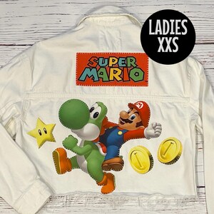 May include: White denim jacket with a Super Mario graphic featuring Yoshi and Mario. The jacket has a distressed hem and the text "LADIES XXS" on the upper right corner.